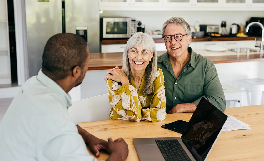 Smiling couple discussing with consultant.